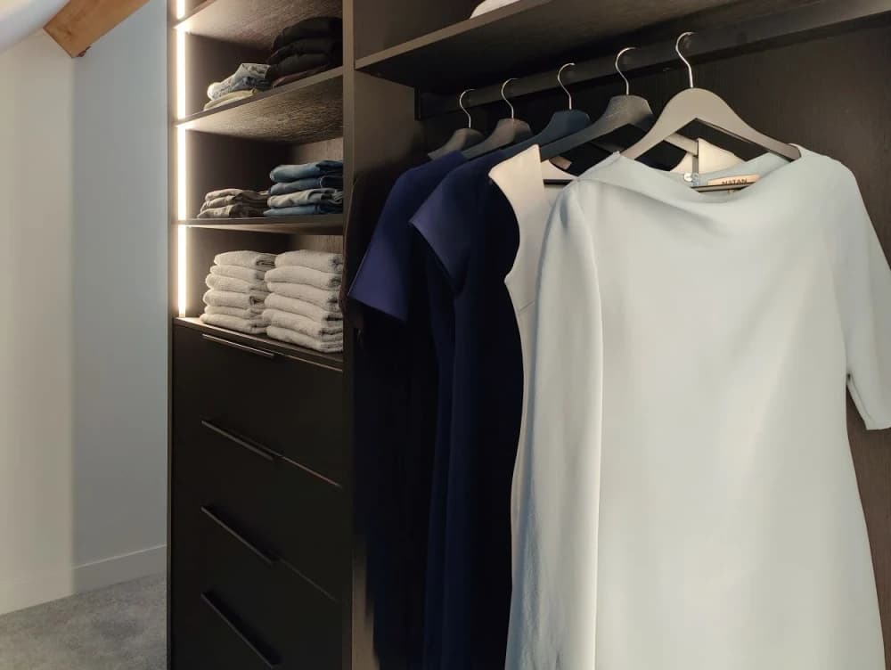 1. Donkere kledingkast op maat met hanggedeelte, legplanken voor opgevouwen kleding en lades.