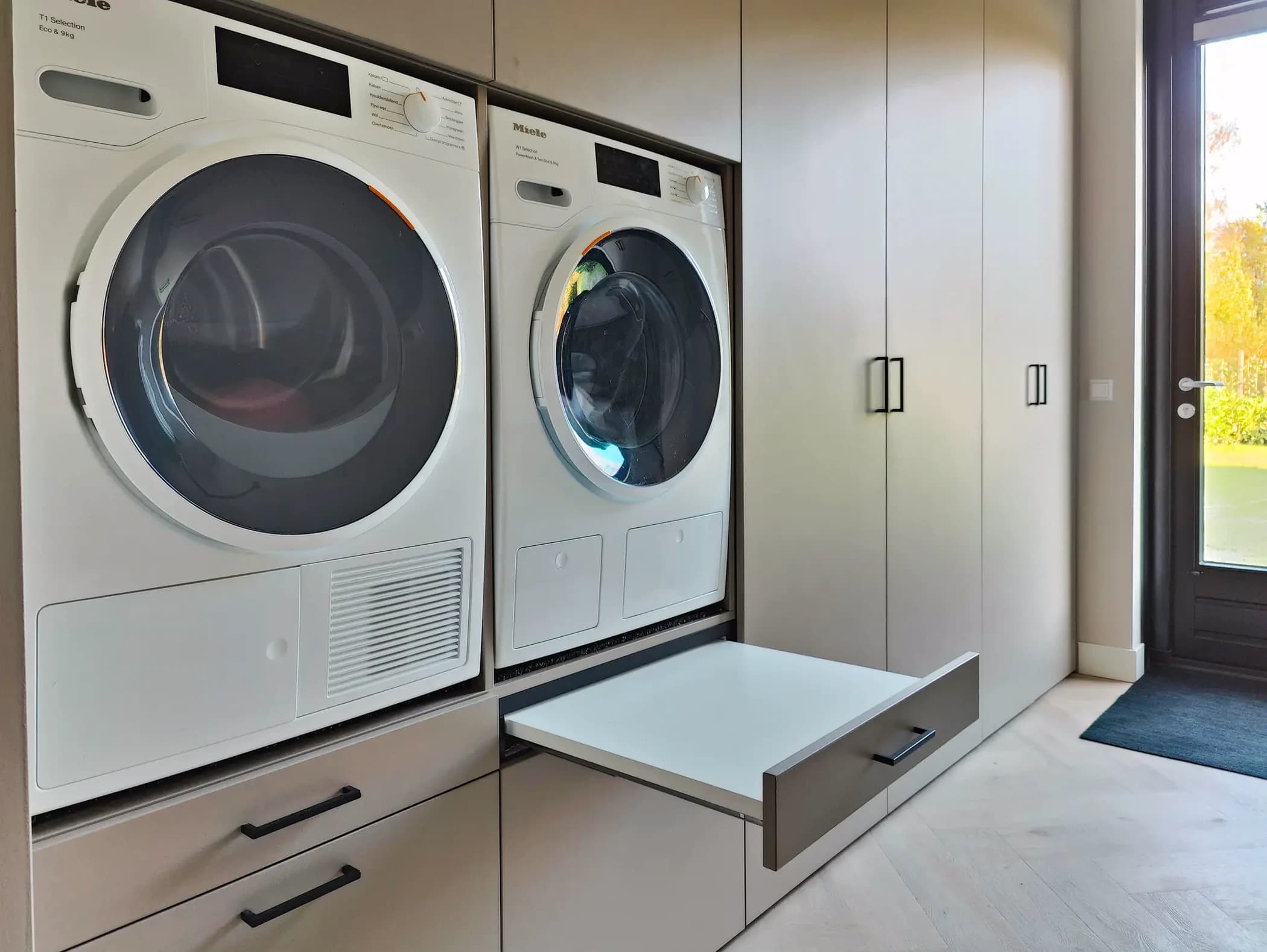 Detail van bijkeuken kast met uittrekbare wasmand lades